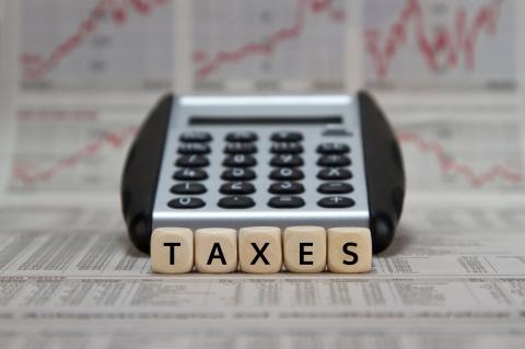 Image of worksheets, calculator, and tiles spelling out "taxes"