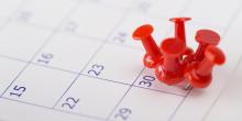 Calendar with pushpins to mark deadline